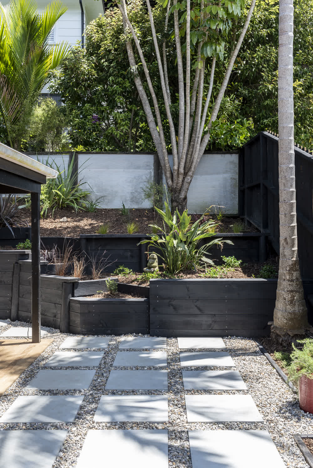 White pavers with stone base and tiered retaining wall